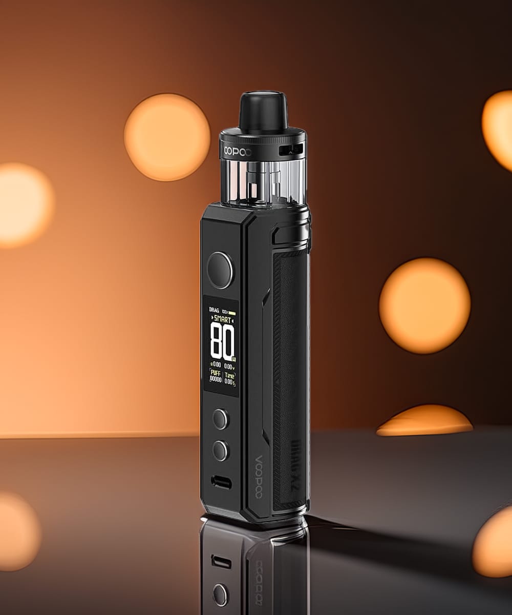 DRAG X2 de Voopoo en finition noire mate sur fond ambré avec effets bokeh dorés, écran TFT affichant 80W